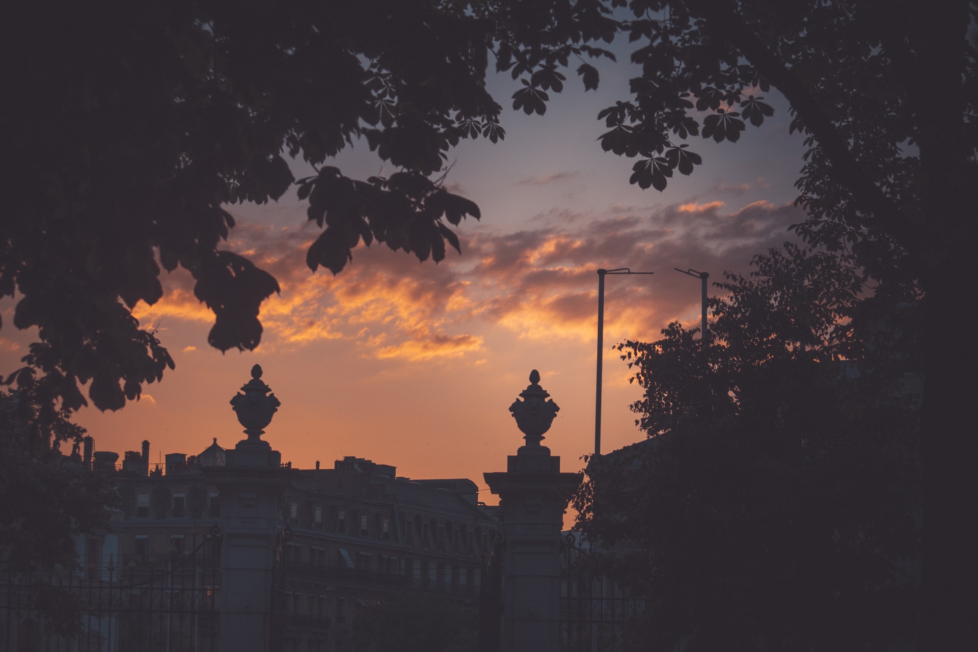 the sun is setting over a city with tall buildings